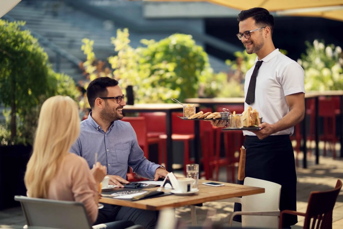 Waiter serves couple outdoors
