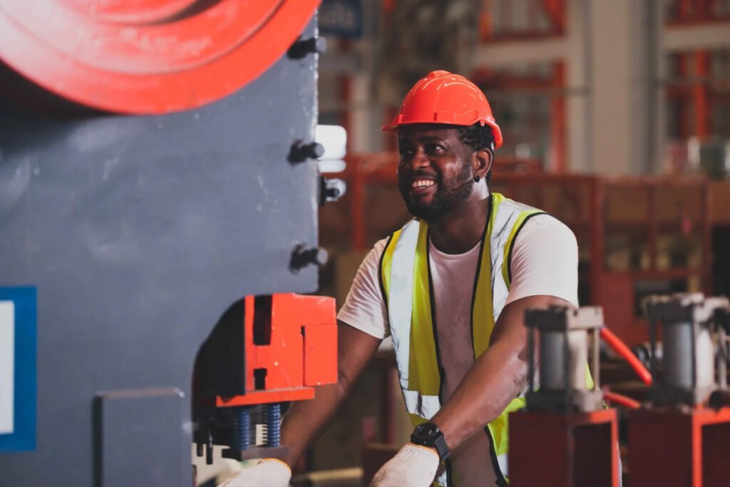 Black worker in hard hat smiles