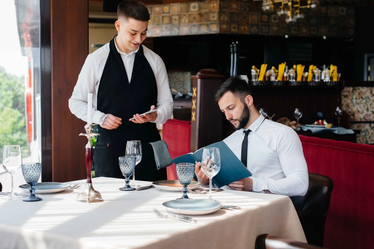 Young Waiter Serving to businessman